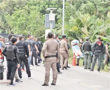  ??  ?? Police secure the area as authoritie­s recover the bodies of a Buddhist and a Muslim policemen in the restive southern Thailand province of Narathiwat. — AFP photo