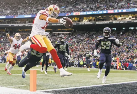  ?? Abbie Parr / Getty Images ?? The 49ers’ Dante Pettis catches the ball over Tedric Thompson of the Seahawks. Pettis had TD catches of 17 and 75 yards.