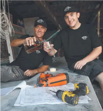  ?? Picture: GLENN HAMPSON ?? Father-son team David and Luke Ridden toast the success of their venture, Granddad Jack's, a Burleigh gin and whiskey distillery which is under constructi­on.