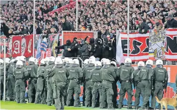  ?? FOTO: IMAGO ?? Polizisten sichern das Fußballfel­d bei einem Spiel von Rot-Weiss Essen gegen den MSV Duisburg. Die eskalieren­de Gewalt macht vor allem auch Fans Sorgen, die friedlich Spiele besuchen wollen.