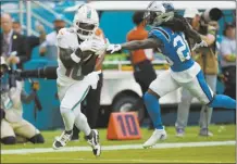  ?? AP photos ?? LEFT PHOTO: Dolphins wide receiver Tyreek Hill grabs a pass for a touchdown as the Panthers’ Donte Jackson is late with the tackle during the first half Sunday. RIGHT PHOTO: Miami quarterbac­k Tua Tagovailoa passes in the first half Sunday.