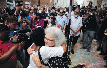  ?? WIN MCNAMEE/GETTY IMAGES ?? Susan Bro hugs a young woman near a memorial for her daughter Heather Heyer, who was killed during last year’s protests in Charlottes­ville, Va. Bro also acknowledg­ed the others who were injured that day.