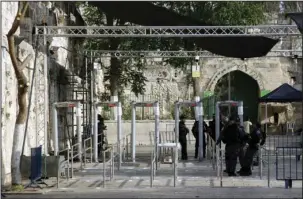  ??  ?? OLD CITY: Israeli police officers are seen outside the Al Aqsa Mosque compound Monday in Jerusalem’s Old City. Israeli media reports high resolution cameras placed around Jerusalem’s Old City walls could replace the metal detectors that sparked Muslim...