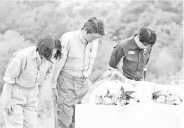  ??  ?? Abe (centre) pays a silent tribute to the victims of the torrential rain in Kurashiki, Okayama Prefecture, Japan. — Reuters photo