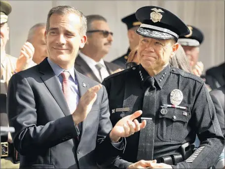  ?? Al Seib Los Angeles Times ?? LOS ANGELES Mayor Eric Garcetti, left, with police Chief Michel Moore, who currently collects nearly $600,000 a year from city coffers — about $350,000 a year in salary from the Police Department and $240,000 a year from the police and fire pension fund.