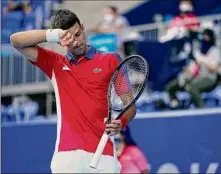  ?? Patrick Semansky / Associated Press ?? Novak Djokovic of Serbia wipes sweat from his brow as he competes against Hugo Dellien of Bolivia during the tennis competitio­n Saturday. Djokovic, going for a golden slam, said he constantly felt dehydrated during his match.