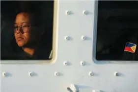  ?? AP PHOTO/AARON FAVILA ?? On April 23, Philippine Coast Guard apprentice seawoman Alinea Pagay monitors a nearby Chinese Coast Guard vessel onboard the BRP Malabrigo as it patrols Philippine-occupied areas in the South China Sea.