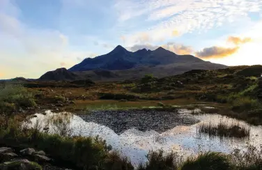  ??  ?? OPPOSITE Walkers bravely tackle the perilously sloping face of the aptly named ‘Bad Step’ above the waters of Loch nan Leachd RIGHT, TOP The imposing jagged peaks of the Black Cuillins seen from Sligachan
RIGHT, CENTRE Thomas Telford’s old stone bridge over the River Sligachan is now disused