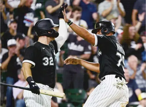  ?? QUINN HARRIS/GETTY IMAGES ?? Jose Abreu high-fives Gavin Sheets after scoring the go-ahead run in the seventh inning Saturday on a single by Andrew Vaughn.