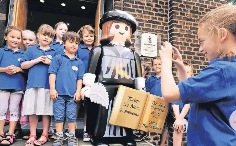  ?? RP-FOTOS (2): ACHIM BLAZY ?? Am Portal der Evangelisc­hen Stadtkirch­e gab es die Playmobilf­igur des Reformator­s Martin Luther zu sehen. Das lud nicht nur die Kinder des Chors „Die Ohrwürmer“zum eifrigen Selfie-Schießen ein.