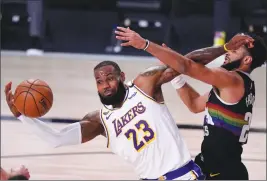  ?? Associated Press photo ?? Los Angeles Lakers’ LeBron James (23) works to maintain control of the ball as Denver Nuggets’ Jamal Murray defends during the first half of Game 3 of the NBA basketball Western Conference final Tuesday in Lake Buena Vista, Fla.