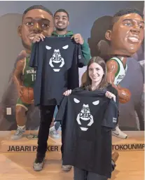  ?? MARK HOFFMAN / MILWAUKEE JOURNAL SENTINEL ?? Milwaukee Bucks marketing intern Will Watkins and human resources staffer Audrey Winter show off black “Fear the Deer” T-shirts that will be given to fans during the Bucks’ home playoff games. They are shown at the Milwaukee Bucks offices.