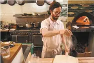  ??  ?? Chef Martin Salata sprinkles flour on a wooden paddle as he makes pizza at Boot & Shoe Service.