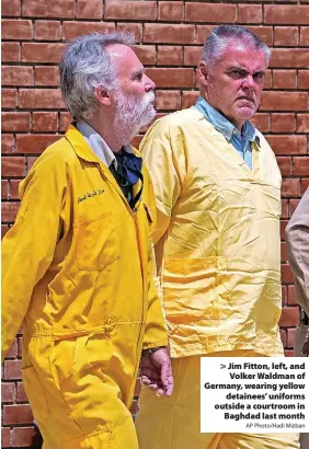  ?? AP Photo/Hadi Mizban ?? Jim Fitton, left, and Volker Waldman of Germany, wearing yellow detainees’ uniforms outside a courtroom in Baghdad last month