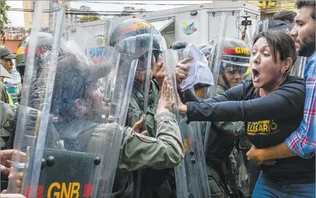  ?? Juan Barreto AFP/Getty Images ?? OPPOSITION DEPUTY Amelia Belisario scuff les with National Guard personnel in riot gear during a protest Friday.