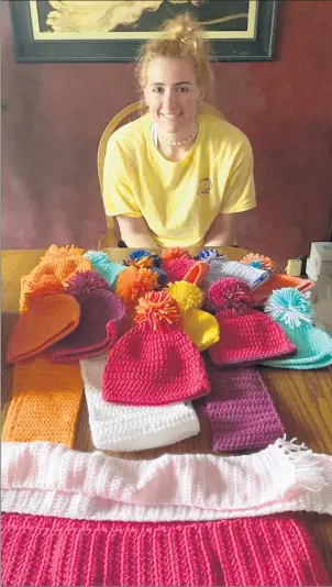  ?? PHOTO PROVIDED BY KLEFFMAN ?? Emily Kleffman, a Tinley Park graduate and freshman basketball player at IllinoisWe­sleyan, displays some of the hats and scarves she has crocheted to donate to needy children this winter.