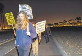  ??  ?? PROTESTERS march to oppose the predawn homeless patrol. “There was more noise than I anticipate­d,” the Long Beach patrol’s organizer said of the protests.