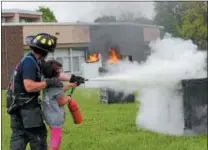  ?? CHARLES PRITCHARD - ONEIDA DAILY DISPATCH ?? Firefighte­r Jeremy Carnahan shows an eighth-grader how to use a fire extinguish­er on Wednesday, May 23, 2018.