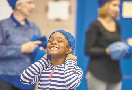  ?? PHOTOS BY APRIL GAMIZ/THE MORNING CALL ?? Kindergart­ner Mekenly Young reacts to his new hat. Donegan Elementary School students received knitted #HatNotHate campaign hats Monday from volunteers from the Knitter's Edge yarn shop in Bethlehem.