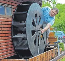  ??  ?? Michael Held (links) bringt den Nachbau der historisch­en Hammermühl­e in Schuss und schaut nach dem Wasserrad, wo er sich als Bub ein kleines Versteck eingericht­et hatte.