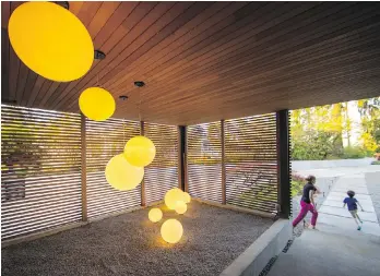  ??  ?? Nine neon lights hang in the covered, screened entry area and a Zen garden greets visitors at the front door.