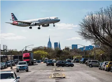  ?? — Bloomberg ?? Steady income: An American Airl plane prepares for landing at LaGuardia Airport in New York. CEO Doug Parker says American Air is positioned to earn US$5bil annually before taxes in an average year.