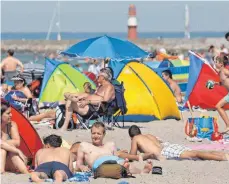  ?? FOTOS: DPA ?? Ein Land, zwei Wetterlage­n. Während vor allem in der Südhälfte Deutschlan­ds am Freitag und Samstag Unwetter mit Starkregen und Sturmböen herrschten, wie hier in Regensburg, freuten sich die Badegäste am Ostseestra­nd über heißes Sommerwett­er. Am Sonntag...