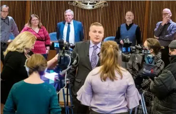  ?? Herald photo by Ian Martens ?? City Manager Bramwell Strain, with mayor and council standing in the background, speaks with reporters Tuesday at city hall as council announced it had accepted his resignatio­n set for early in the new year. @IMartensHe­rald