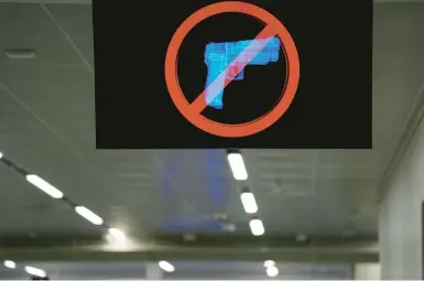  ?? BRYNN ANDERSON/AP ?? A TV monitor displays a “no guns” sign at Atlanta’s airport, which had 448 guns intercepte­d by TSA staffers in 2022.