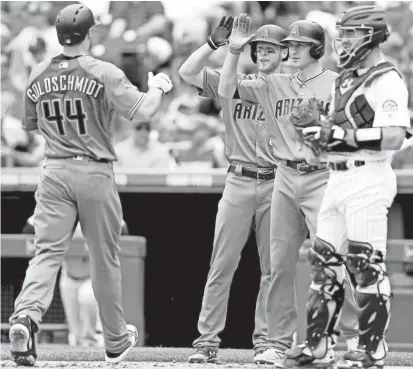  ?? MATTHEW STOCKMAN/GETTY IMAGES ?? Paul Goldschmid­t is congratula­ted at home plate by Jeremy Hazelbaker (left) and Nick Ahmed after homering against the Rockies on Thursday.