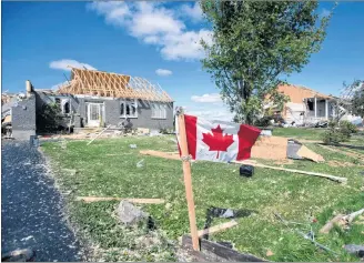  ?? CP PHOTO ?? A Canadian flag flies in front of homes destroyed by a tornado in Dunrobin, Ont., west of Ottawa, on Saturday.