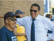  ?? KEVIN RICHARDSON/BALTIMORE SUN ?? Ivan Bates shares a laugh with members of his team outside the William Pace Elementary voting location Tuesday.