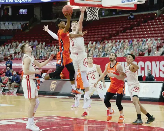  ?? DYLAN BUELL/GETTY IMAGES ?? Illinois’ Trent Frazier goes up for a shot against Wisconsin’s Micah Potter on Saturday in Madison, Wis. Frazier sank two critical free throws with 5.7 seconds left.