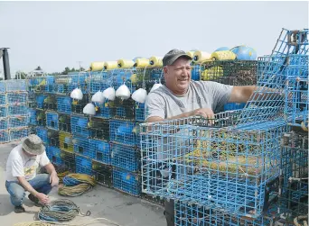  ?? - Acadie Nouvelle: Jean-Marc Doiron ?? Paul LeBlanc prépare ses casiers au quai de Chockpish en vue de la prochaine saison de pêche au homard dans le détroit de Northumber­land.