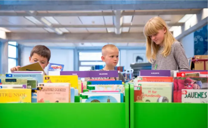  ?? ANDERS MINGE ?? Kim F. Helgevold, til venstre, Jonas H. Haugsvaer og Nina Steinhaug Ådnøy på jakt etter gode bøker på barnebibli­oteket. Arkivbilde hentet fra 2016.