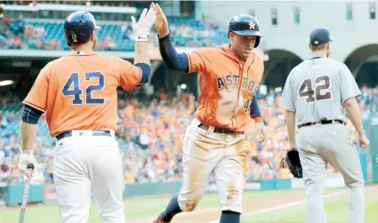  ??  ?? George Springer es felicitado por su compañero Tyler White, luego de anotar para los Astros de Houston durante la primera entrada del juego ante los Tigres de Detroit. Esa fue la única carrera del partido.