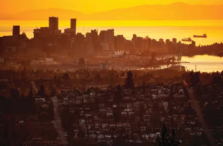 ??  ?? The downtown Vancouver skyline is seen at sunset, as houses line a hillside in Burnaby, British Columbia, on Saturday, April 17, 2021. Photo: AP