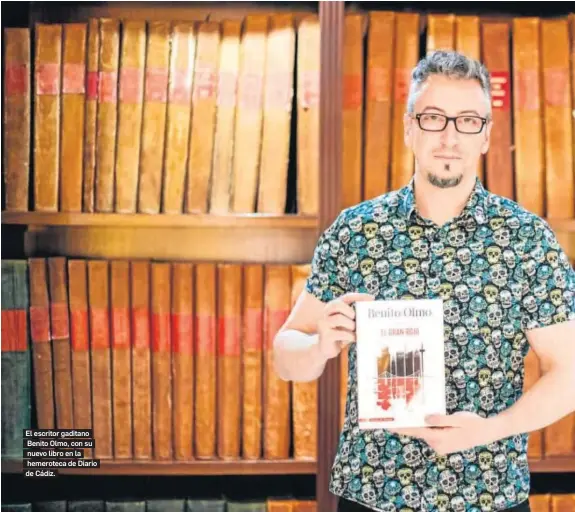  ??  ?? El escritor gaditano Benito Olmo, con su nuevo libro en la hemeroteca de Diario de Cádiz.