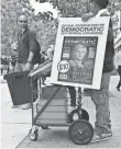 ?? NICHOLAS KAMM, AFP/GETTY IMAGES ?? Selling convention programs in Philadelph­ia on Monday.