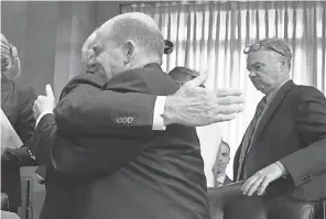  ?? J. SCOTT APPLEWHITE/AP ?? Sen. Chris Coons, D-Del., right, is embraced by Sen. Bob Corker, R-Tenn., after Coons’ collegial gesture of voting “present” instead of “no” on a committee vote about moving ahead on Mike Pompeo for secretary of state.