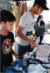  ??  ?? The writer and his brother volunteeri­ng at a free market to help the flood victims in Trong, Perak recently.