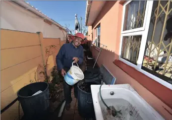  ?? PICTURES: JASON BOUD ?? Pensioner Johnny Basson, from Steenberg, uses rainwater from his roof which he collects via drains (downpipes) into a few outdoor baths (right). He either lets the baths overflow through its outlet into basins or buckets, or he uses buckets to scoop...