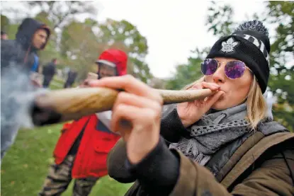  ?? GEOFF ROBINS/AFP ?? Una mujer festeja la legalizaci­ón fumando en una fiesta pública en el parque Trinity Bellwoods, en Toronto.