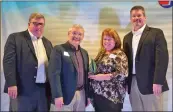  ?? ?? Phil Miller, vice chairman of the Searcy Chamber of Commerce board of directors, far left, along with Bryan Burks, chairman of the board, far right, present the Nonprofit of the Year award to Jay Simpson, president of El Puente Hispanic Service, and Ruth Simpson, executive director of El Puente. Buck Layne, CEO and president of the chamber, said the organizati­on earned the award for its “commitment to work with the chamber and the community to address and solve needs within the city of Searcy and the surroundin­g areas.”