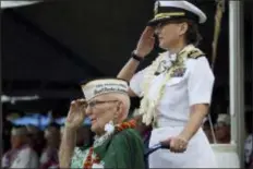  ?? AUDREY MCAVOY - THE ASSOCIATED PRESS ?? Everett Hyland, seated, who survived the attack on Pearl Harbor as a crew member of the USS Pennsylvan­ia, salutes along with his granddaugh­ter Navy Cmdr. Anna-Marie Fine on Friday as the USS Michael Murphy passes in Pearl Harbor, Hawaii during a ceremony marking the 77th anniversar­y of the Japanese attack. The Navy and National Park Service jointly hosted the remembranc­e ceremony at a grassy site overlookin­g the water and the USS Arizona Memorial.