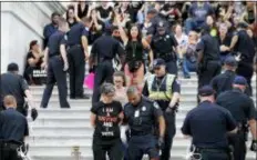  ?? ALEX BRANDON - THE ASSOCIATED PRESS ?? Activists are arrested by Capitol Hill Police officers after occupying the steps on the East Front of the U.S. Capitol as they protest the confirmati­on vote of Supreme Court nominee Brett Kavanaugh on Capitol Hill, Saturday, Oct. 6, in Washington.