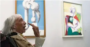  ??  ?? Maya Picasso, the daughter of Spanish painter Pablo Picasso, is seen in front of her father’s paintings.