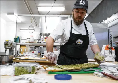  ?? PHOTOS BY GODOFREDO A. VASQUEZ/AP ?? Chef Josh Gjersand prepares a sandwich for Mount Diablo High School students to try during a taste test in Concord, California. The school district in suburban San Francisco has been part of a national “farm-to-school” movement for years, where schools try to buy as much locally as possible. California also provides free meals for public school students.