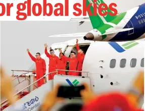  ??  ?? Crew members wave to spectators on China’s homegrown large passenger plane C919 after its maiden flight in Shanghai on May 5, 2017. (XINHUA/Fang Zhe)