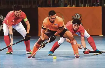  ?? BERNAMA PIC ?? A Malaysia player (centre) vies with Indonesia players in the indoor hockey final of the Sea Games at MITEC on Aug 26. Malaysia won 5-1 for gold.